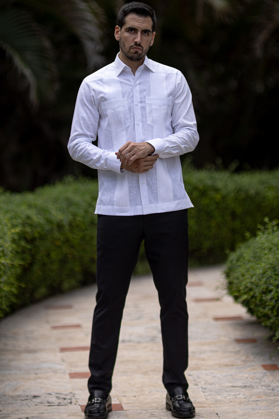 Man wearing a white linen guayabera with vertical pleats and patch pockets
