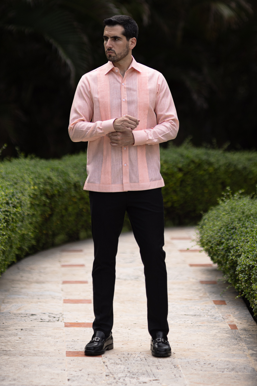 Man wearing a white linen guayabera shirt with four pockets and vertical pleats
